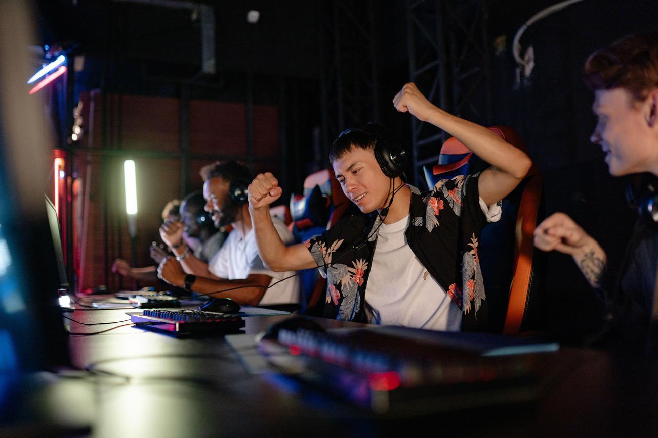 Jugadores emocionados celebrando una victoria en un torneo de videojuegos competitivo.