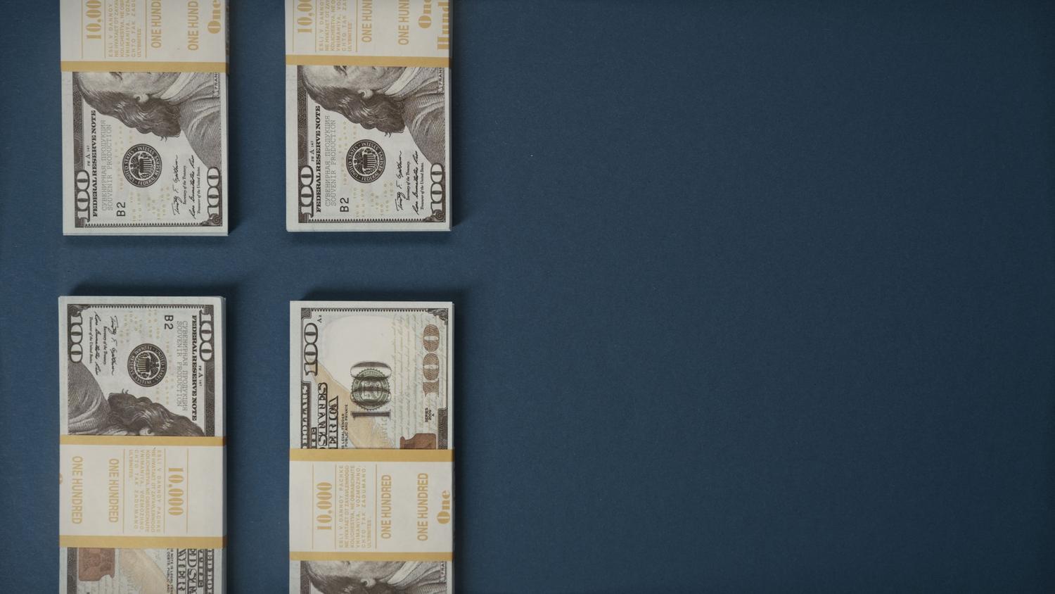 Pilas de billetes de dólares, simbolizando el éxito comercial masivo y la temática de los golpes en GTA V.