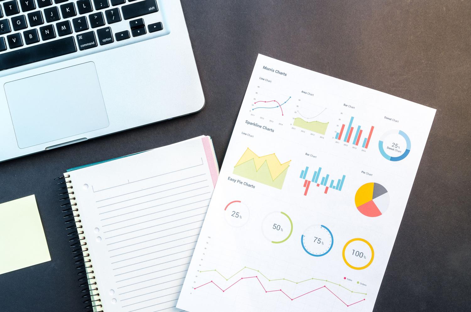 Vista cenital de un informe de negocios con tablas y gráficos, representando la estructura de datos.