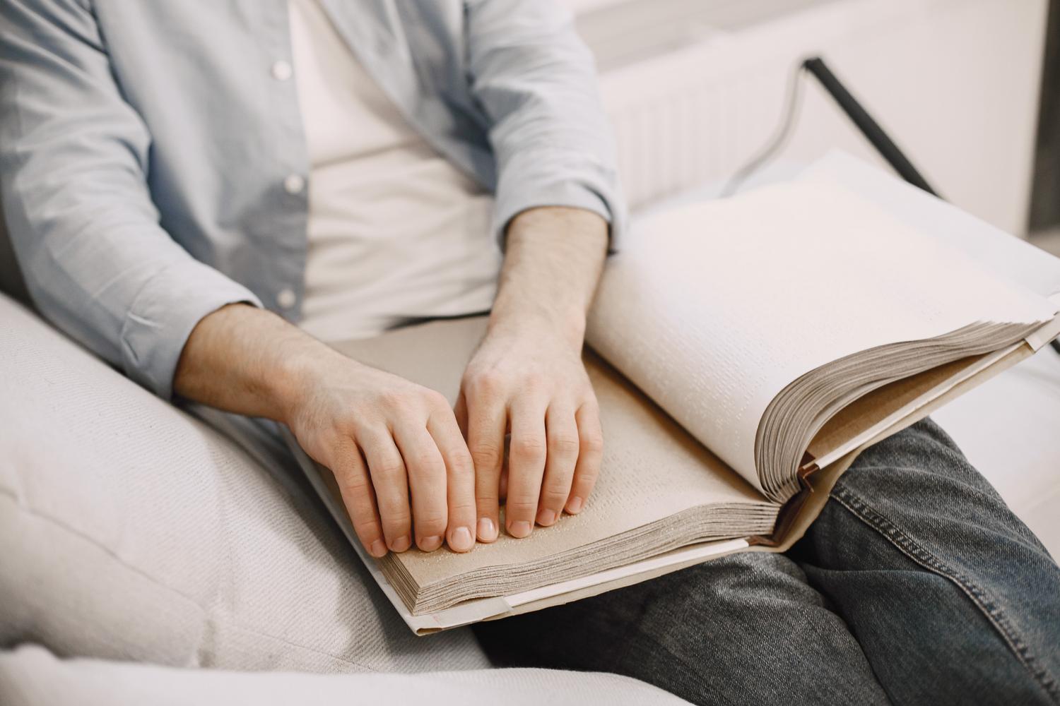 Persona leyendo un libro en braille, simbolizando la importancia de la accesibilidad web y los lectores de pantalla.