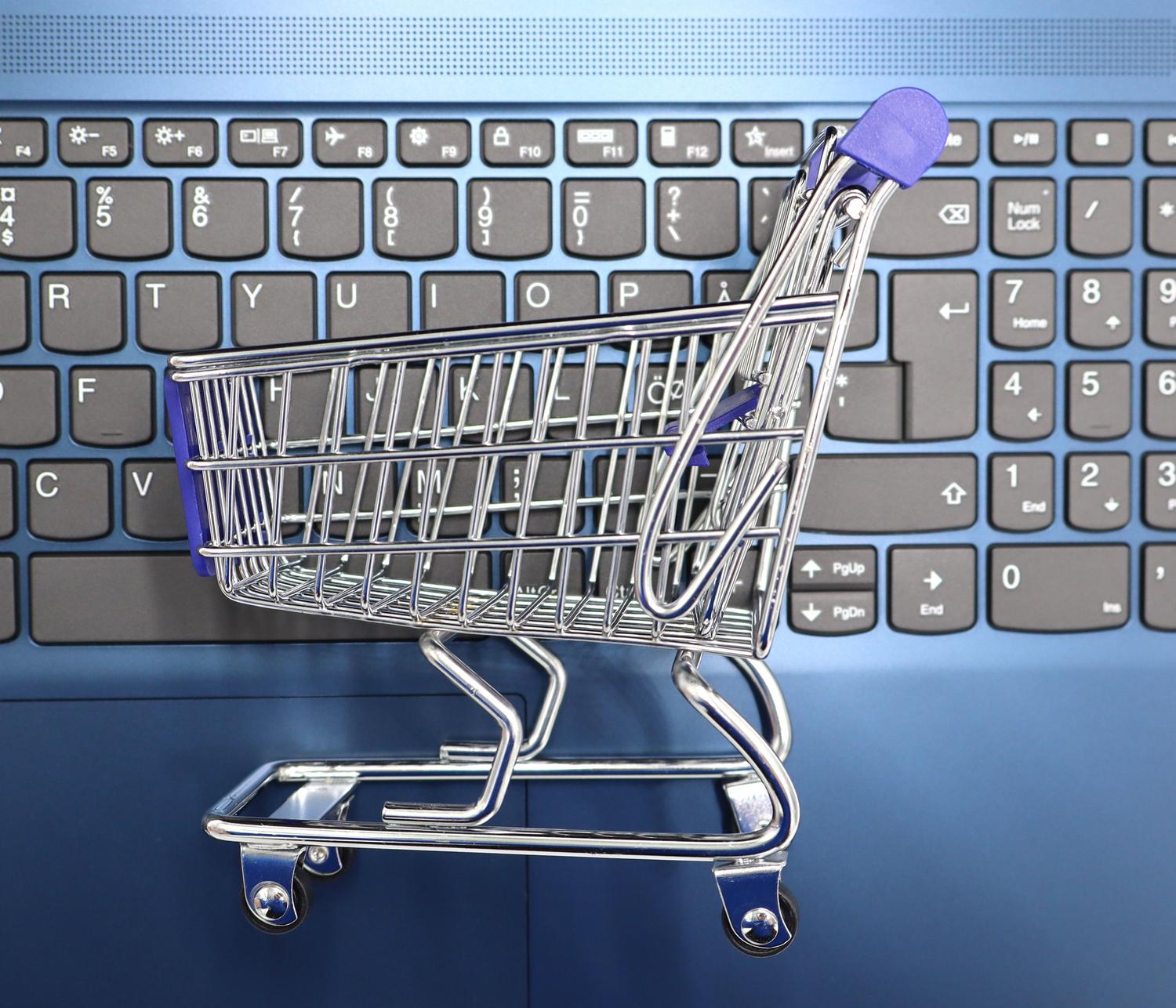 Miniatura de un carrito de compra sobre el teclado de un portátil, representando el concepto general de comercio electrónico y marketplaces.