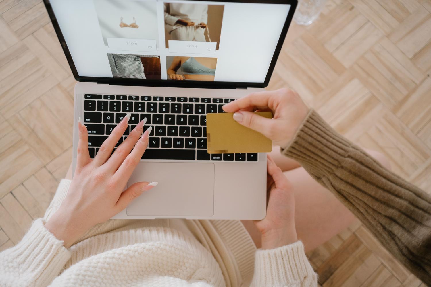 Persona realizando compras online con un portátil y tarjeta de crédito, simbolizando la experiencia de usuario y la personalización.