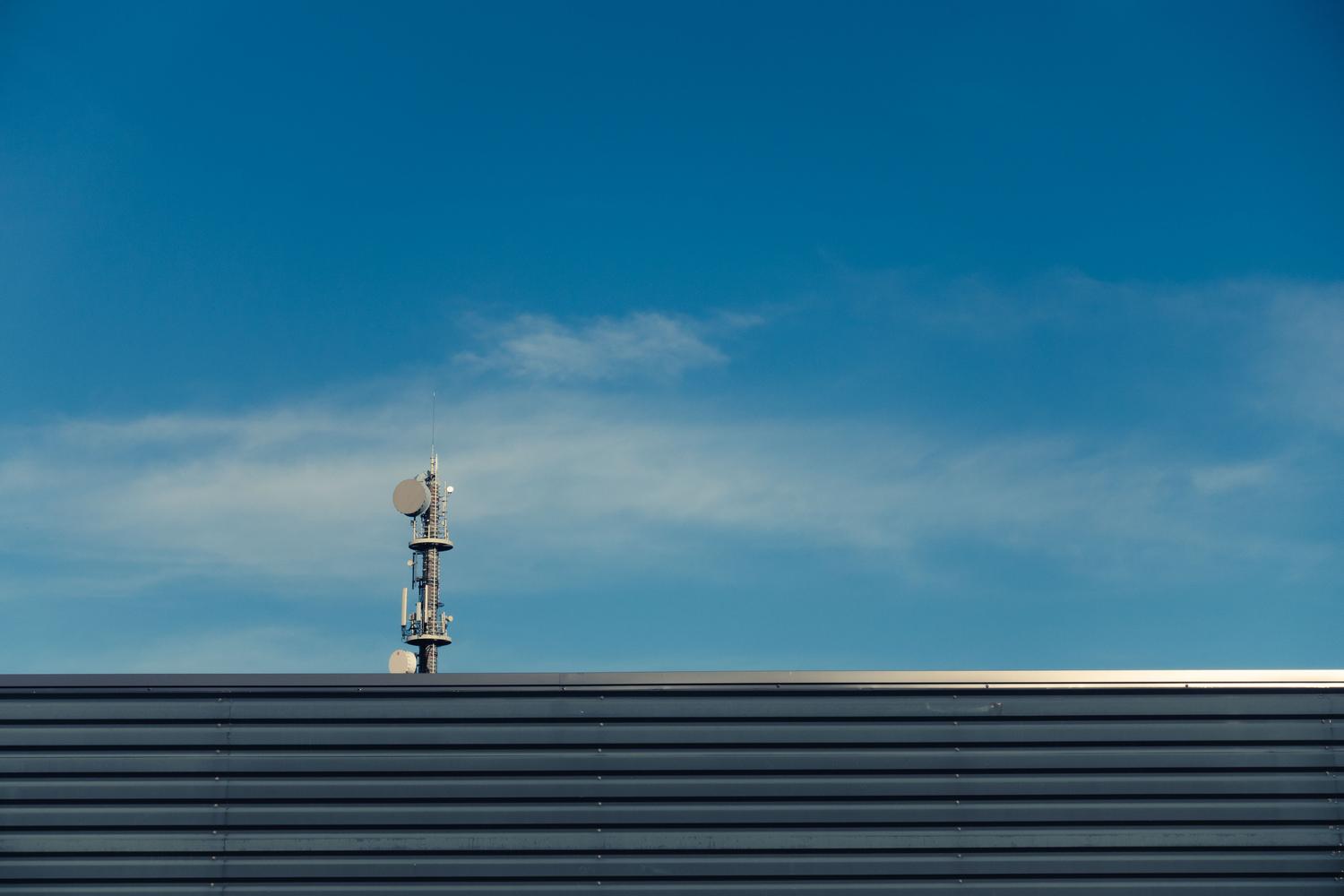Torre de telecomunicaciones moderna bajo un cielo azul, representando la infraestructura de la red 4G y el servicio VoLTE.