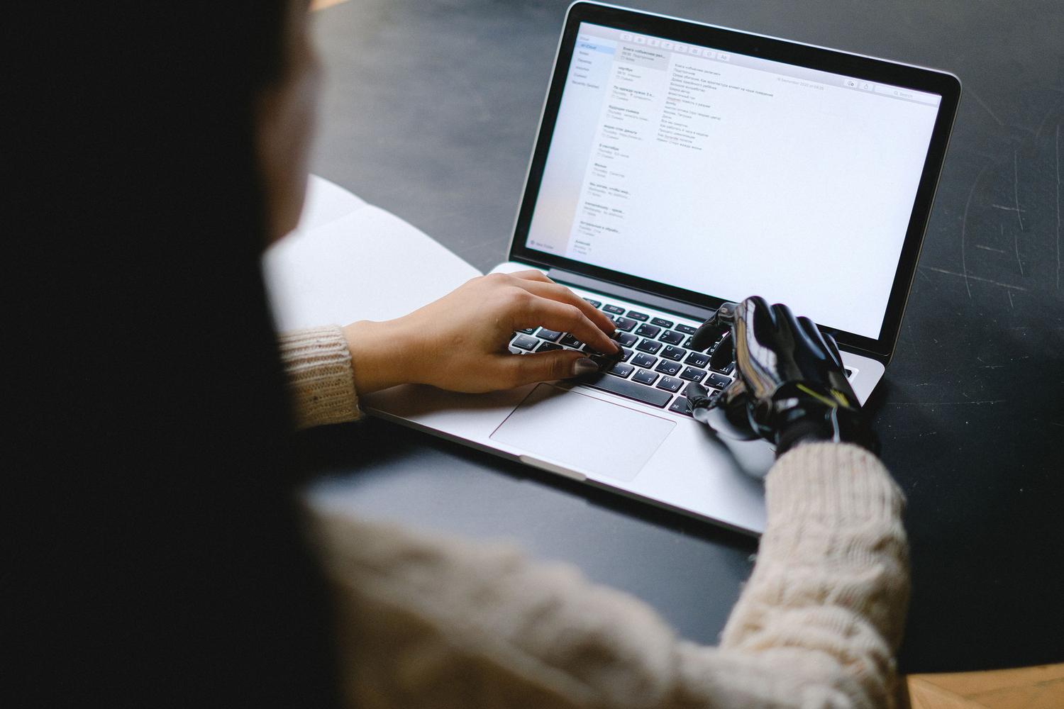 Persona utilizando un portátil, simbolizando la accesibilidad web y la creación de experiencias inclusivas tanto para humanos como para IAs.
