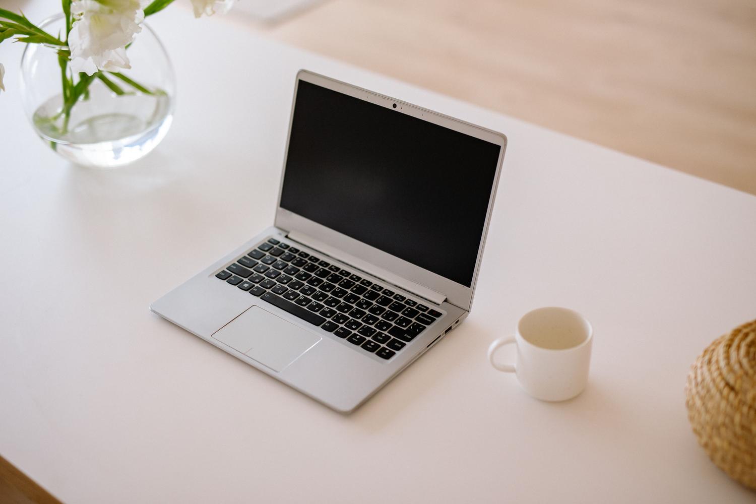 Espacio de trabajo minimalista y limpio con un ordenador portátil, representando la organización y eficiencia de un flujo de trabajo digital optimizado.