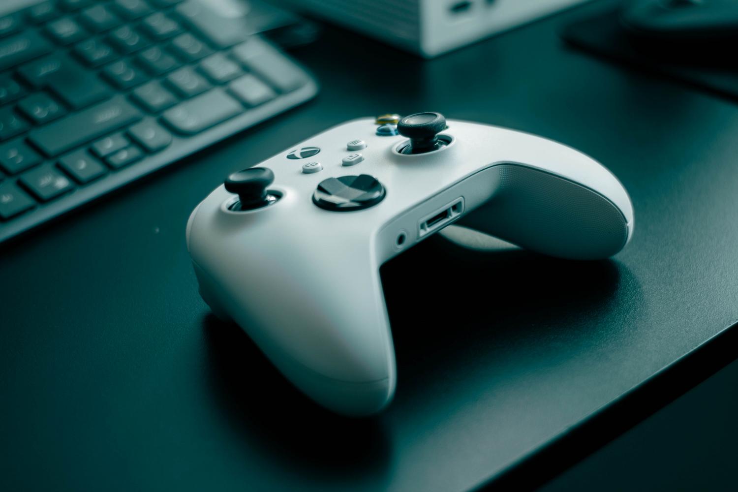 Primer plano de un mando de videojuegos blanco sobre un escritorio elegante.
