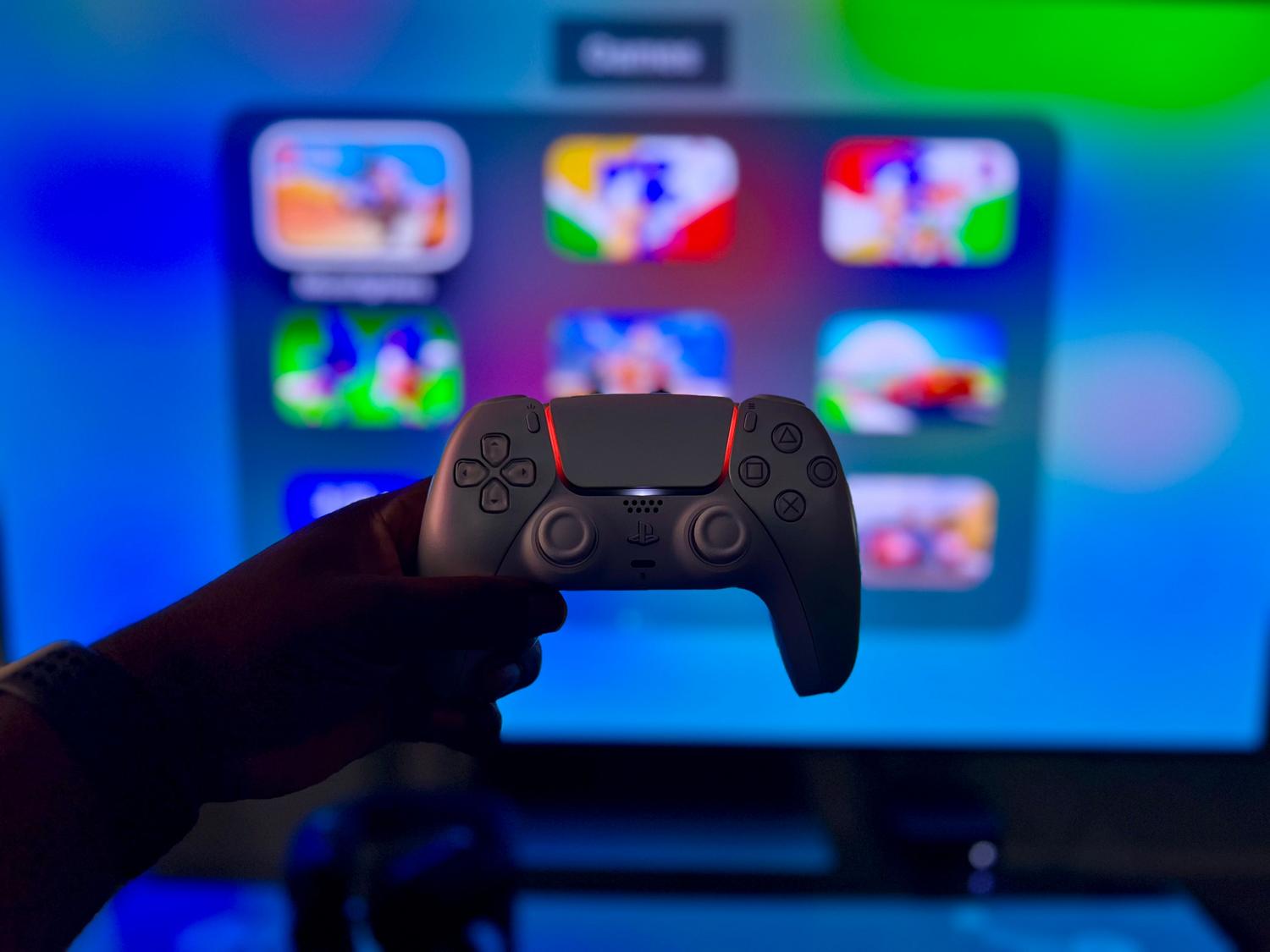 Mando de videojuegos frente a una pantalla vibrante y colorida.