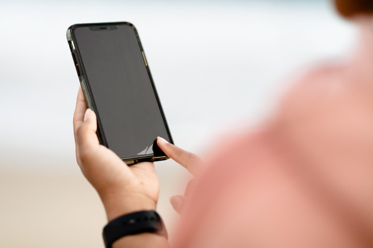 Persona utilizando un smartphone al aire libre, representando la mecánica de evolución y recolección de caramelos en Pokémon GO. Persona utilizando un smartphone al aire libre, representando la mecánica de evolución y recolección de caramelos en Pokémon GO.