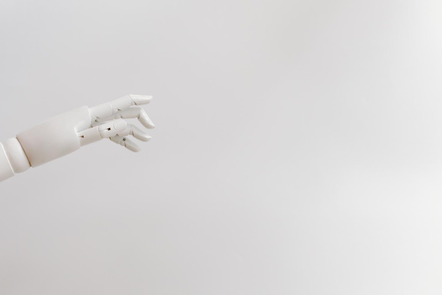 Mano robótica blanca minimalista sobre fondo blanco, ilustrando los sistemas bioinspirados y la imitación de la anatomía humana