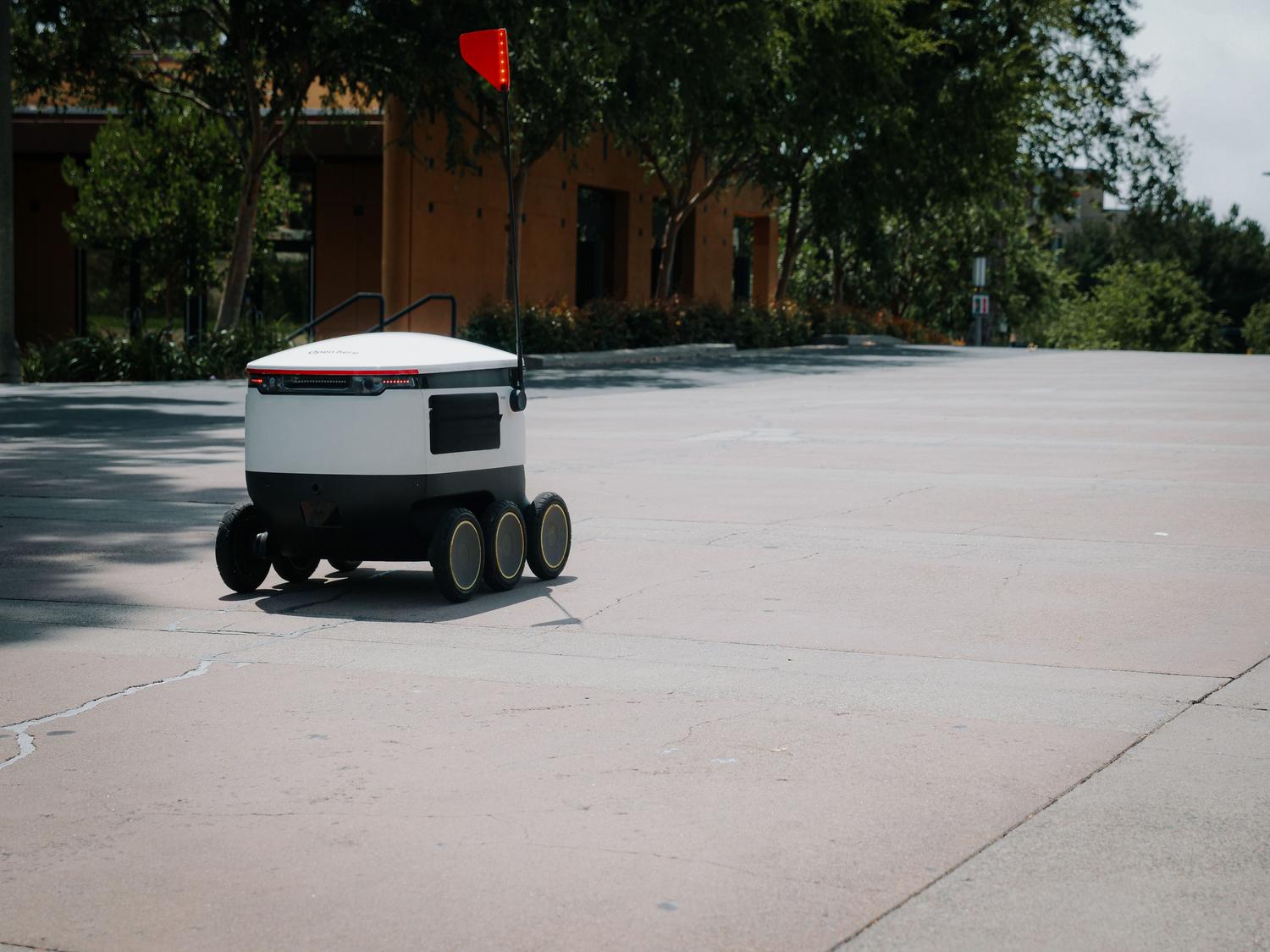 Robot de reparto autónomo navegando por una calle urbana, ejemplificando la robótica autónoma en el mundo real