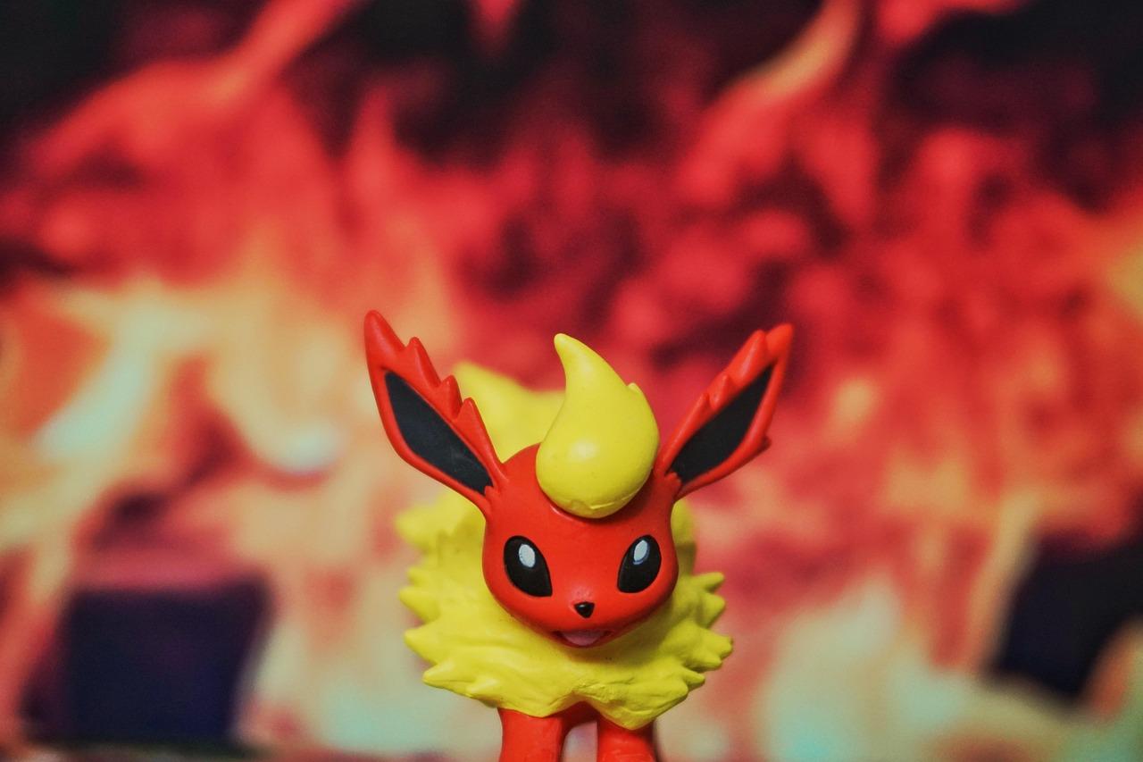 Figura de Flareon, la evolución tipo fuego de Eevee, con un fondo de llamas ardientes