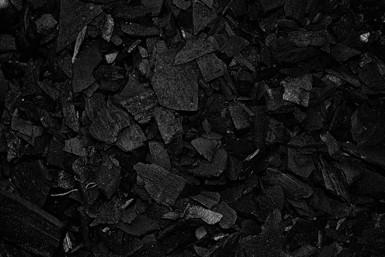 Primer plano de trozos de carbón negro, material esencial para la fundición