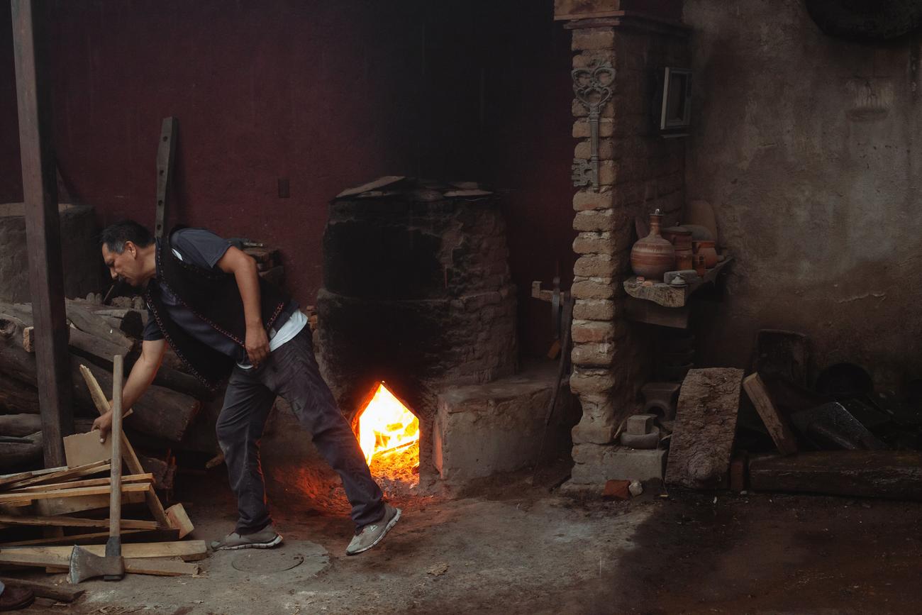 Herrero trabajando en un taller tradicional con un horno encendido