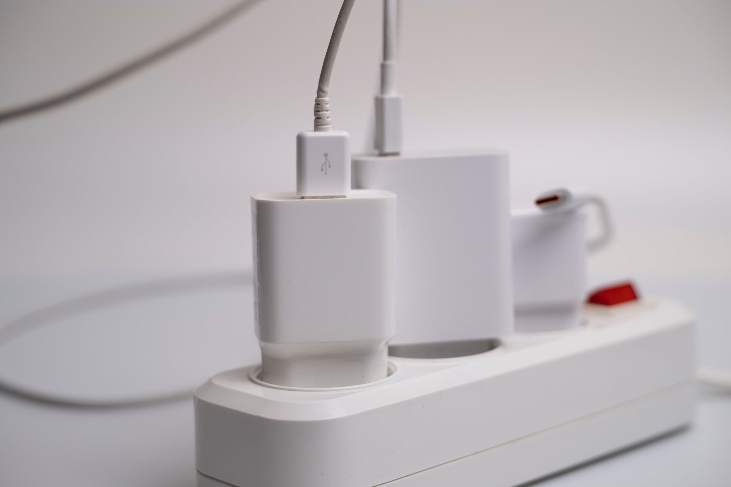 Regleta eléctrica con varios cargadores conectados, representando el consumo fantasma y la protección eléctrica