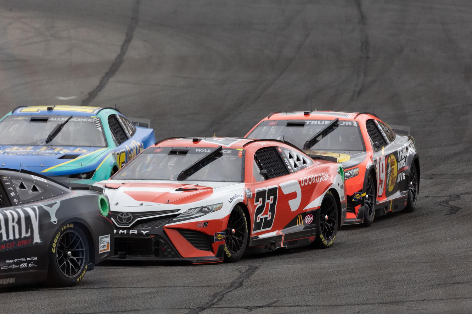 Coches de NASCAR luchando por la posición en formación cerrada, ideal para ilustrar el formato Chase y la IA competitiva.