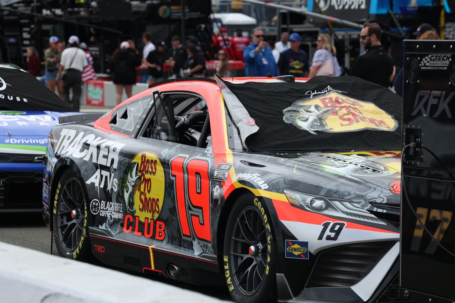 Primer plano de un coche de NASCAR en el paddock, ilustrando la gestión de equipo y las ventajas de la Gold Edition.