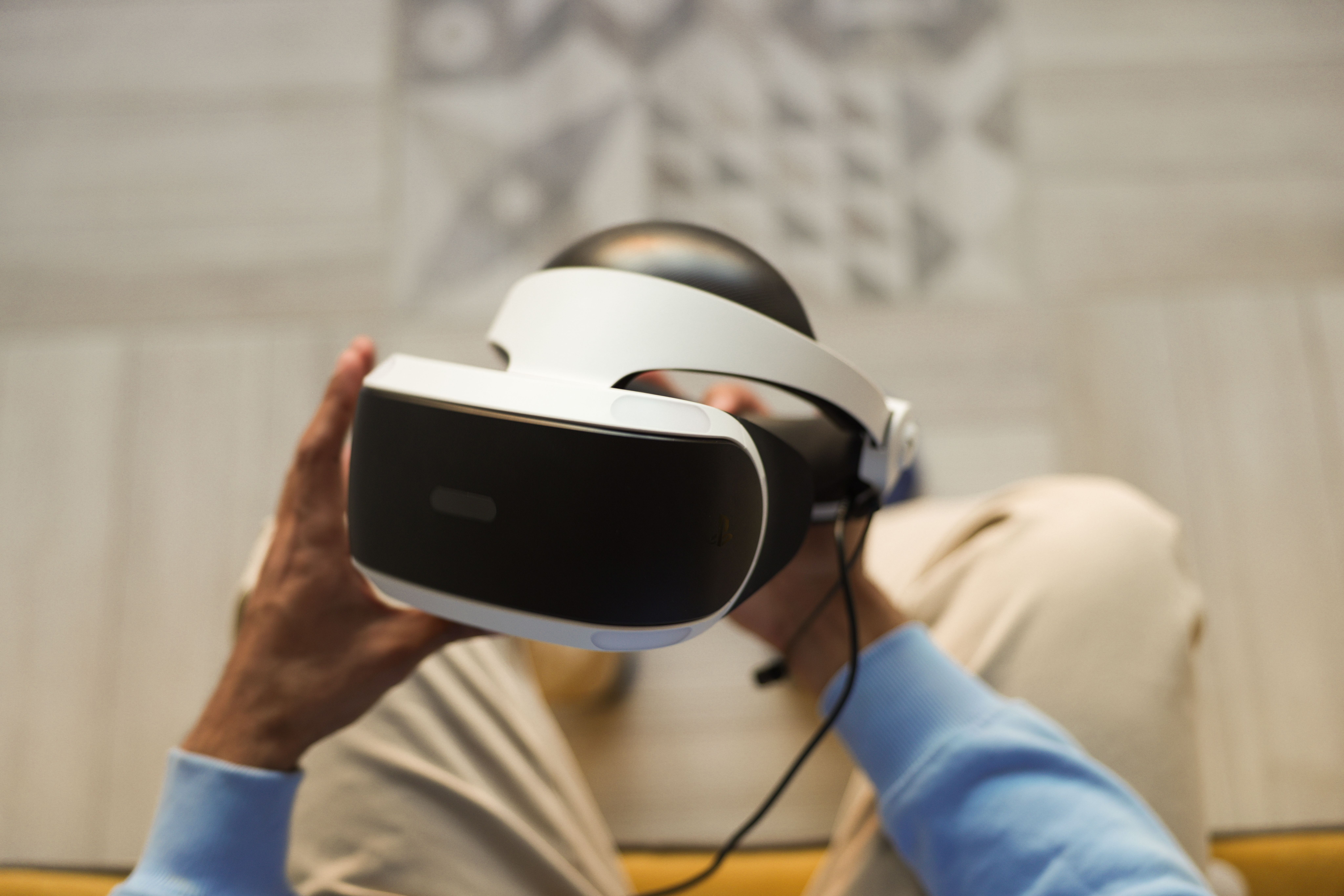Detalle de las manos sosteniendo un visor de realidad virtual, resaltando el hardware del dispositivo. Detalle de las manos sosteniendo un visor de realidad virtual, resaltando el hardware del dispositivo.