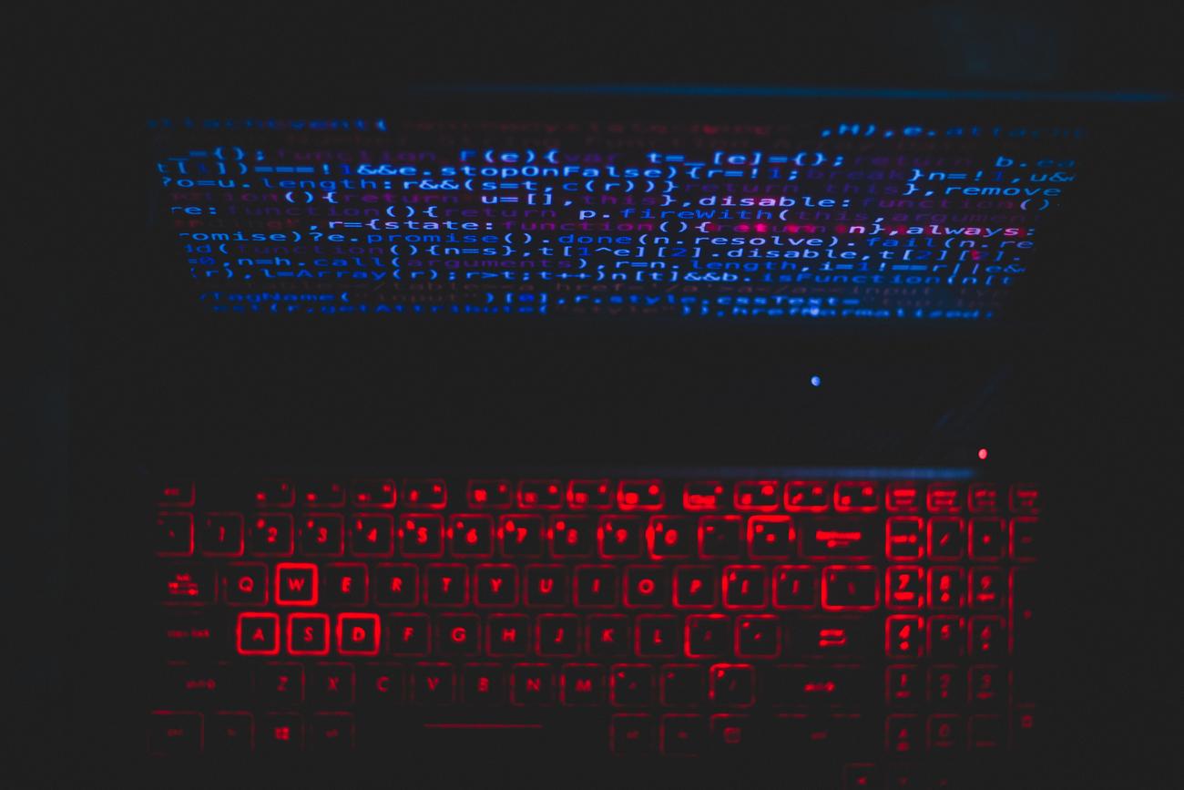 Configuración de portátil con teclado retroiluminado y código en pantalla, simbolizando la seguridad y el enfoque de OpenBSD.