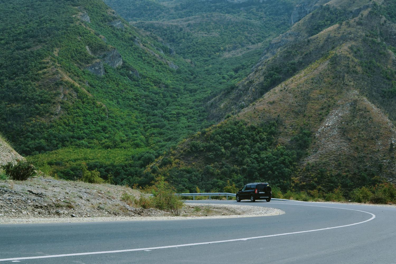 Vista panorámica de un coche circulando por una carretera serpenteante en la montaña, ideal para ilustrar el freno motor.