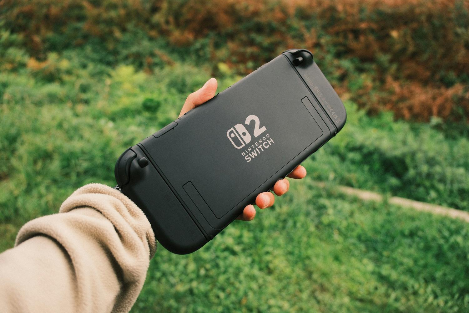 Persona disfrutando de un juego en una consola portátil Nintendo Switch en un entorno natural.