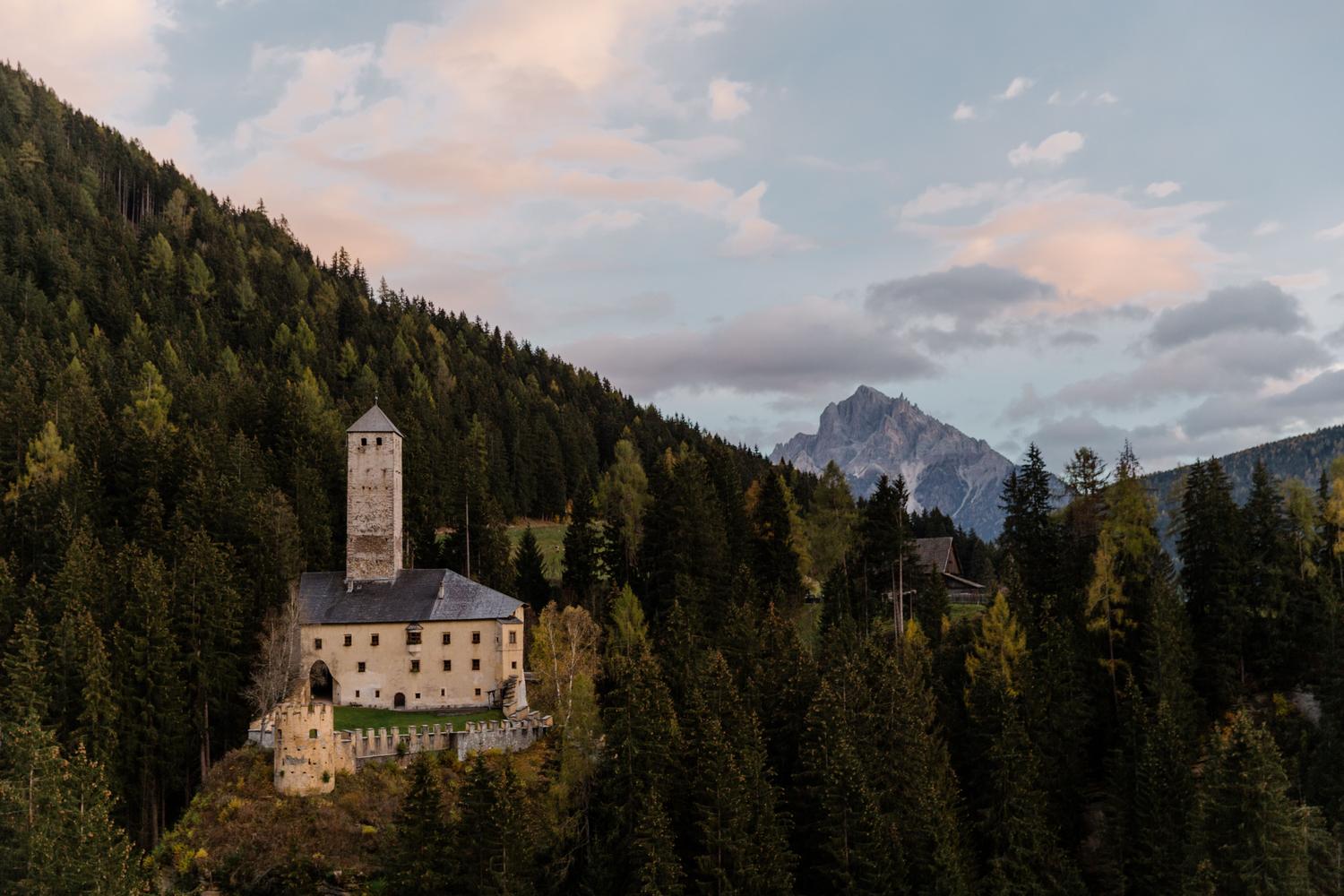 Castillo majestuoso en un paisaje montañoso, representando la ambientación de fantasía épica de Fire Emblem.