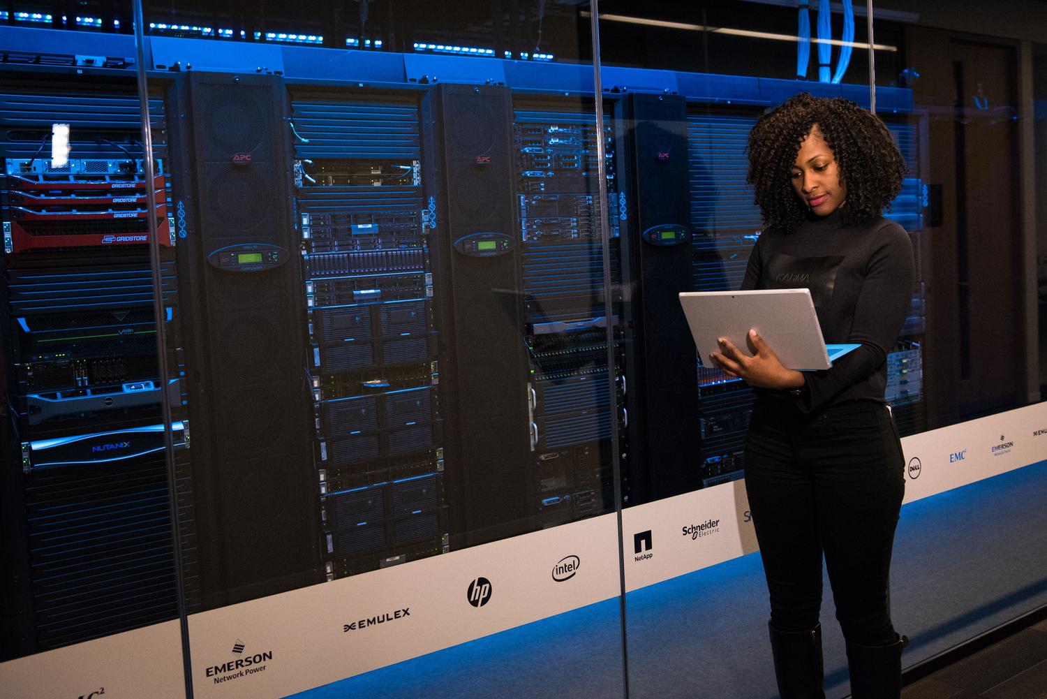 Gestora de seguridad de la información supervisando racks de servidores en un centro de datos moderno