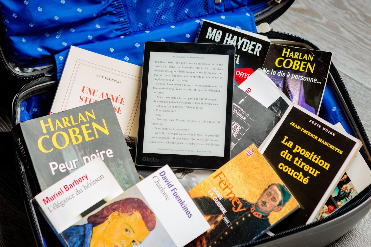 Una maleta abierta con una mezcla de libros físicos y un lector de libros electrónicos, ilustrando el dilema entre la propiedad tradicional tangible y la propiedad digital eficiente.