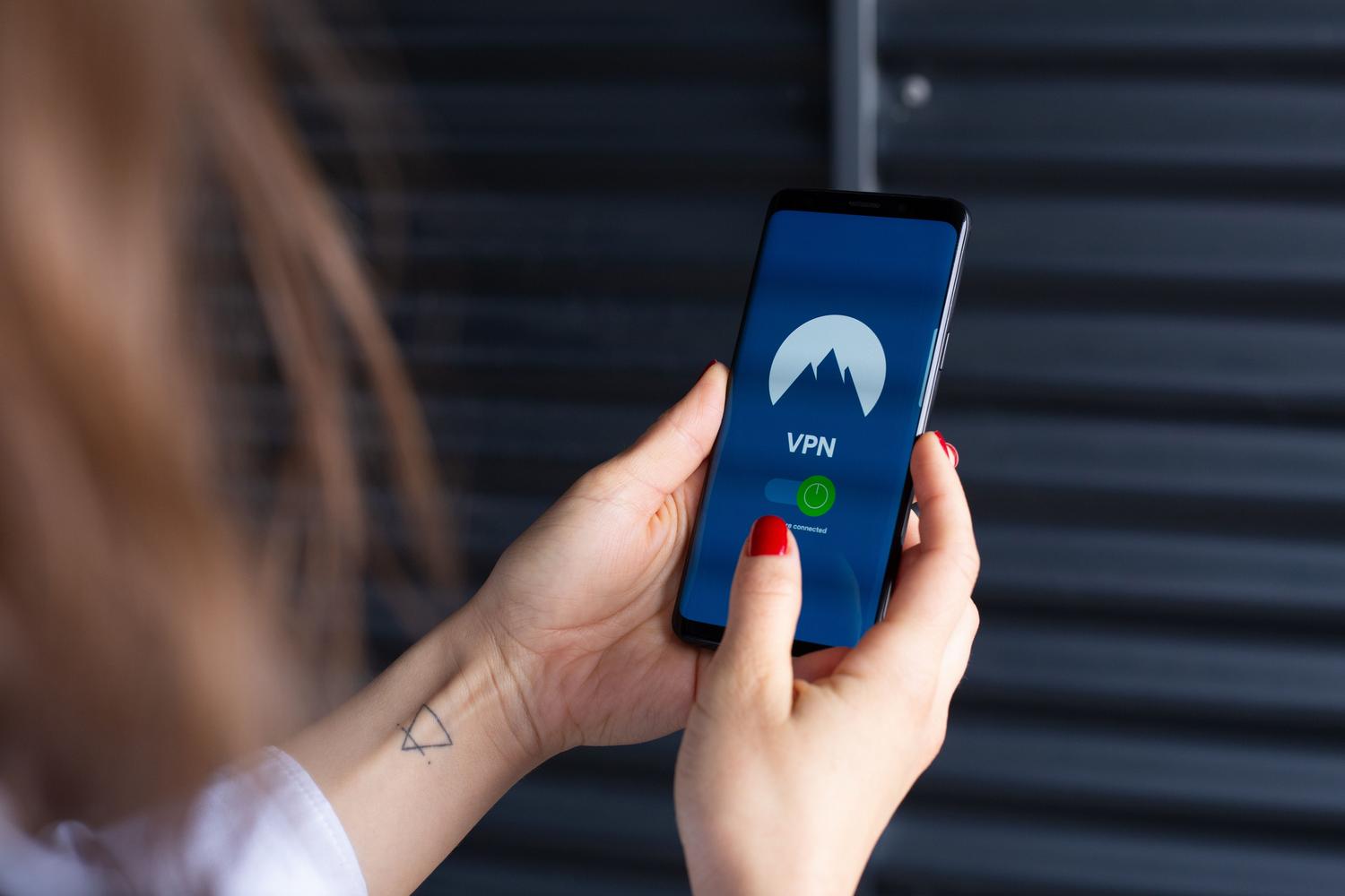Primer plano de una persona activando una aplicación de VPN en un smartphone para asegurar la conexión de red.