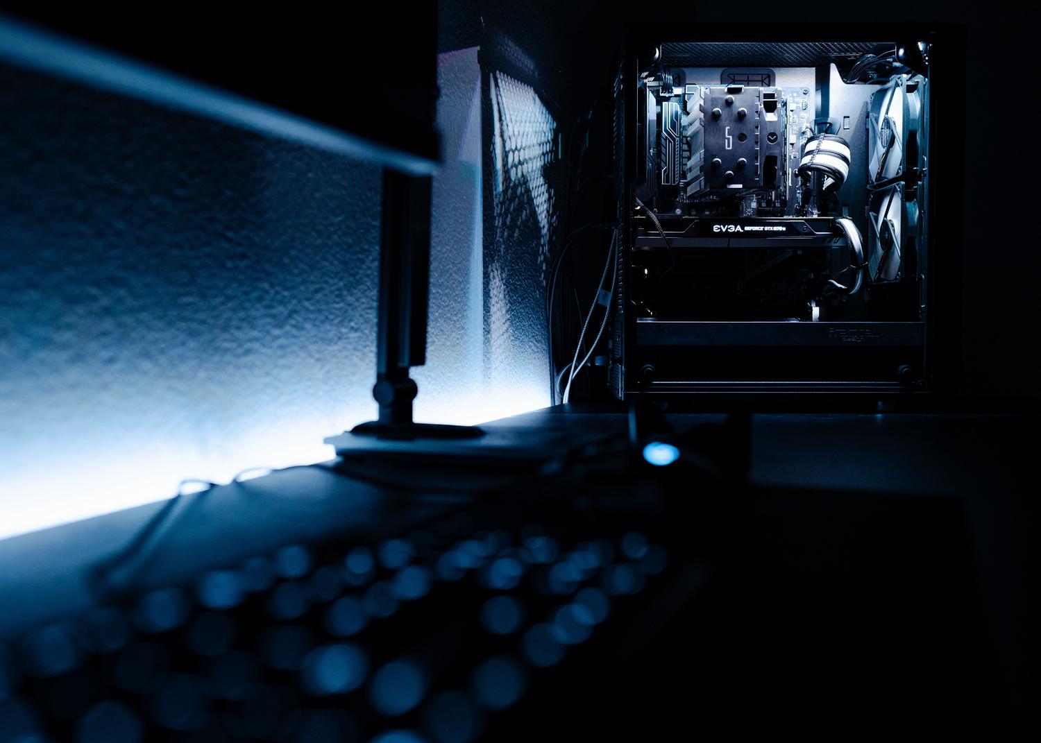 Toma atmosférica y oscura de un PC gaming de gama alta en una habitación minimalista.