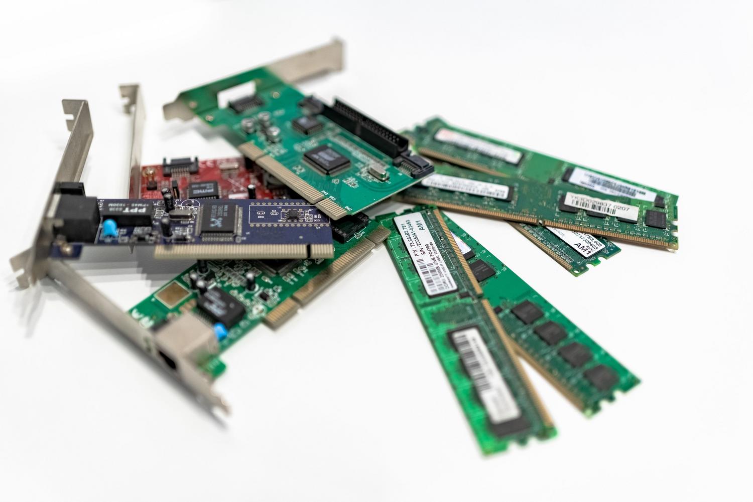 Primer plano de módulos de memoria RAM y tarjetas PCI, representando los requisitos técnicos de hardware.