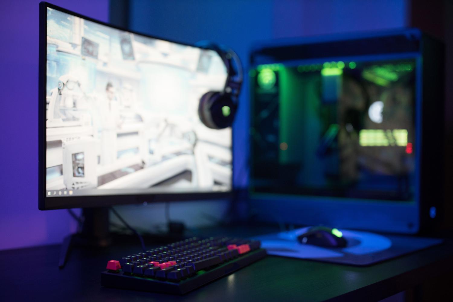 Setup gaming completo con monitor curvo y periféricos RGB, representando la experiencia de juego óptima para DUST Origins.