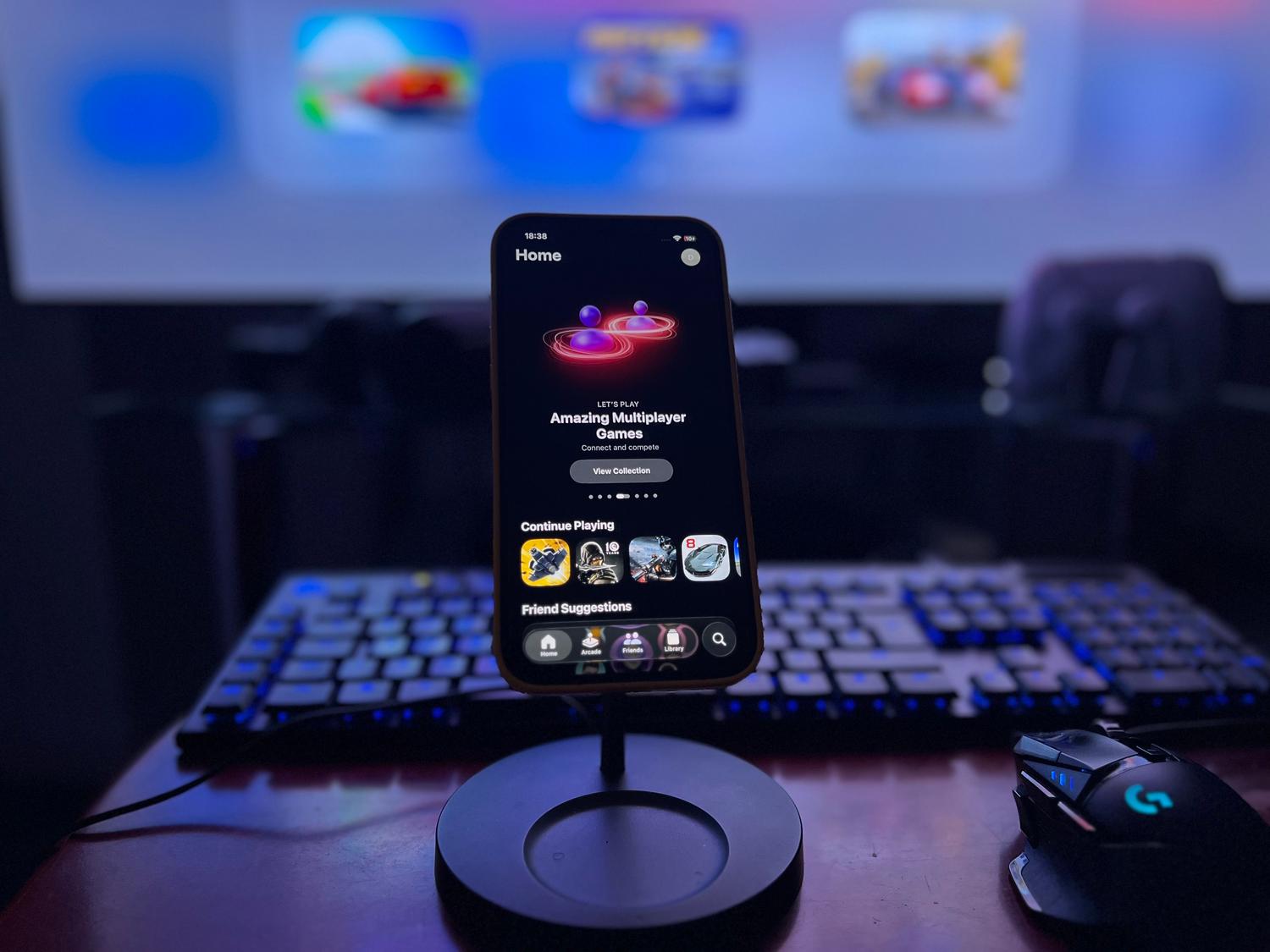 Configuración de gaming moderna con un smartphone en un soporte, teclado y ratón, ideal para ilustrar la versión de Google Play Games para Windows.