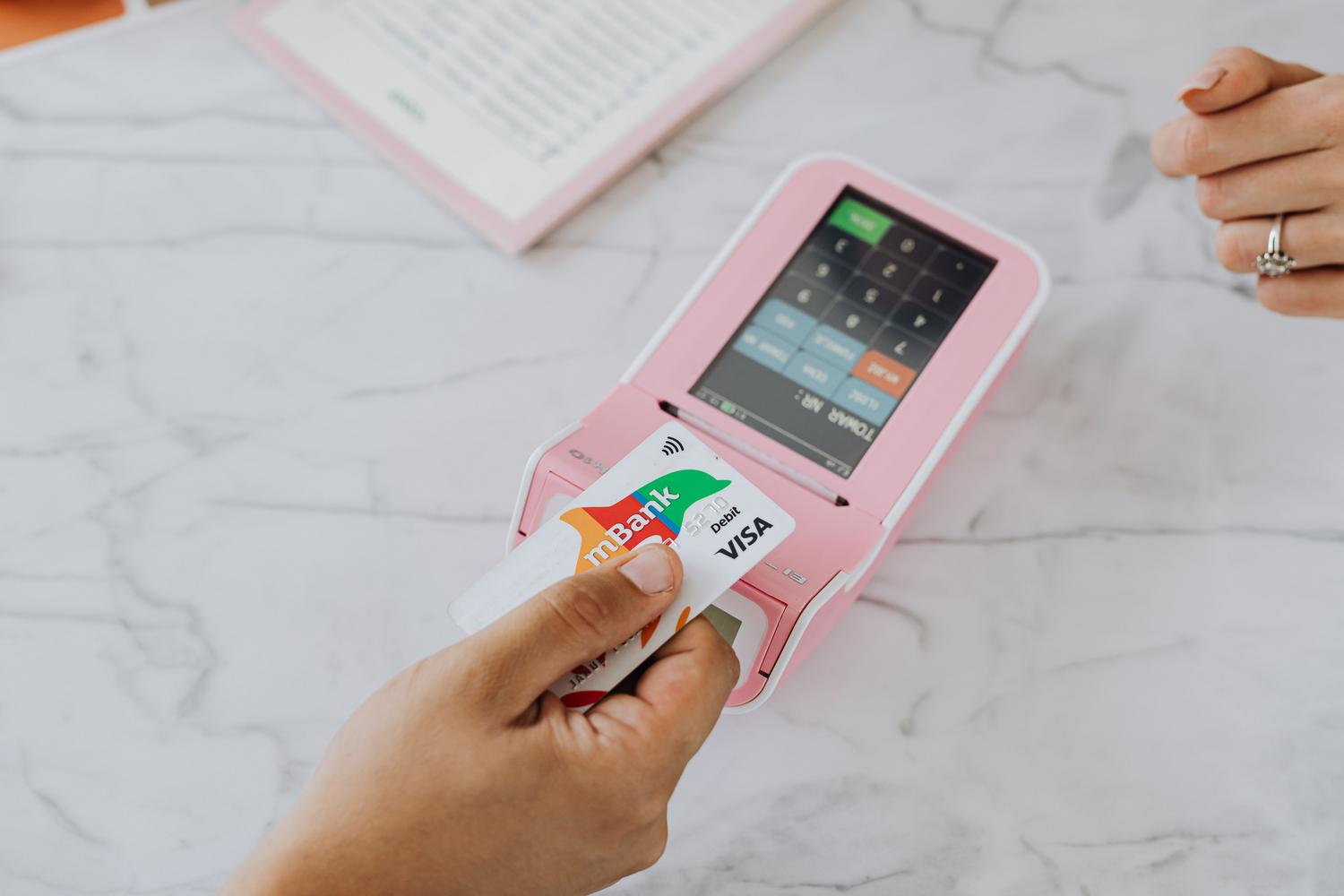 Primer plano de un pago sin contacto (contactless) utilizando una tarjeta en un terminal de punto de venta (POS)