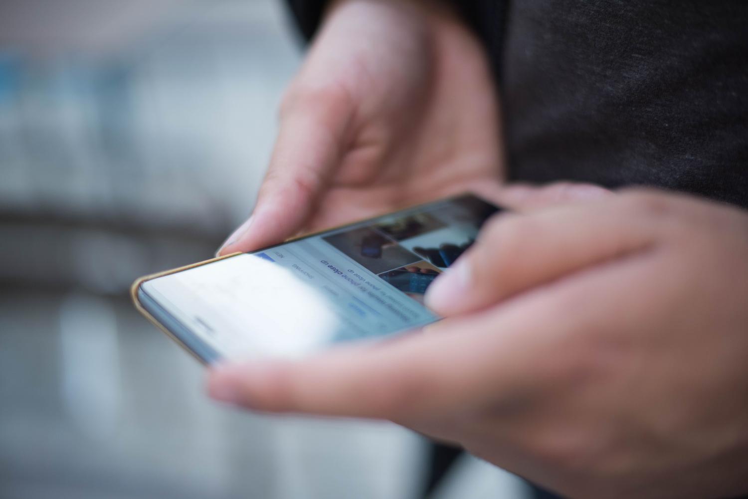 Manos escribiendo un mensaje en la pantalla de un smartphone, ideal para ilustrar trucos de formato y comunicación.
