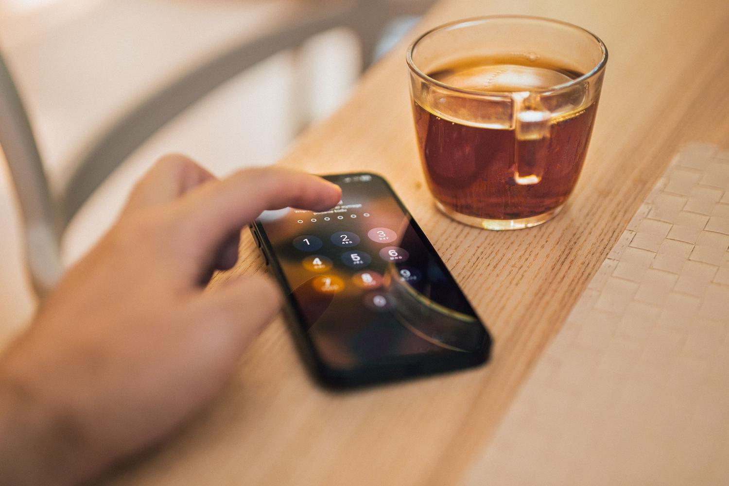 Primer plano de una persona desbloqueando su móvil con un código, simbolizando la seguridad y privacidad de las conversaciones.