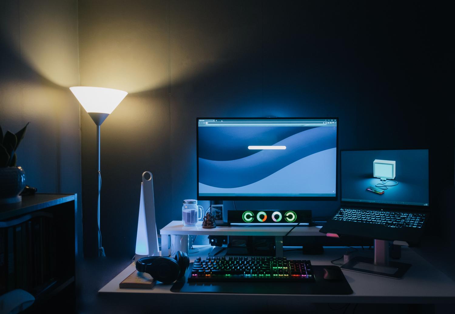Setup de oficina moderna con monitores y luz ambiental, ideal para auditar el rendimiento de equipos gaming.