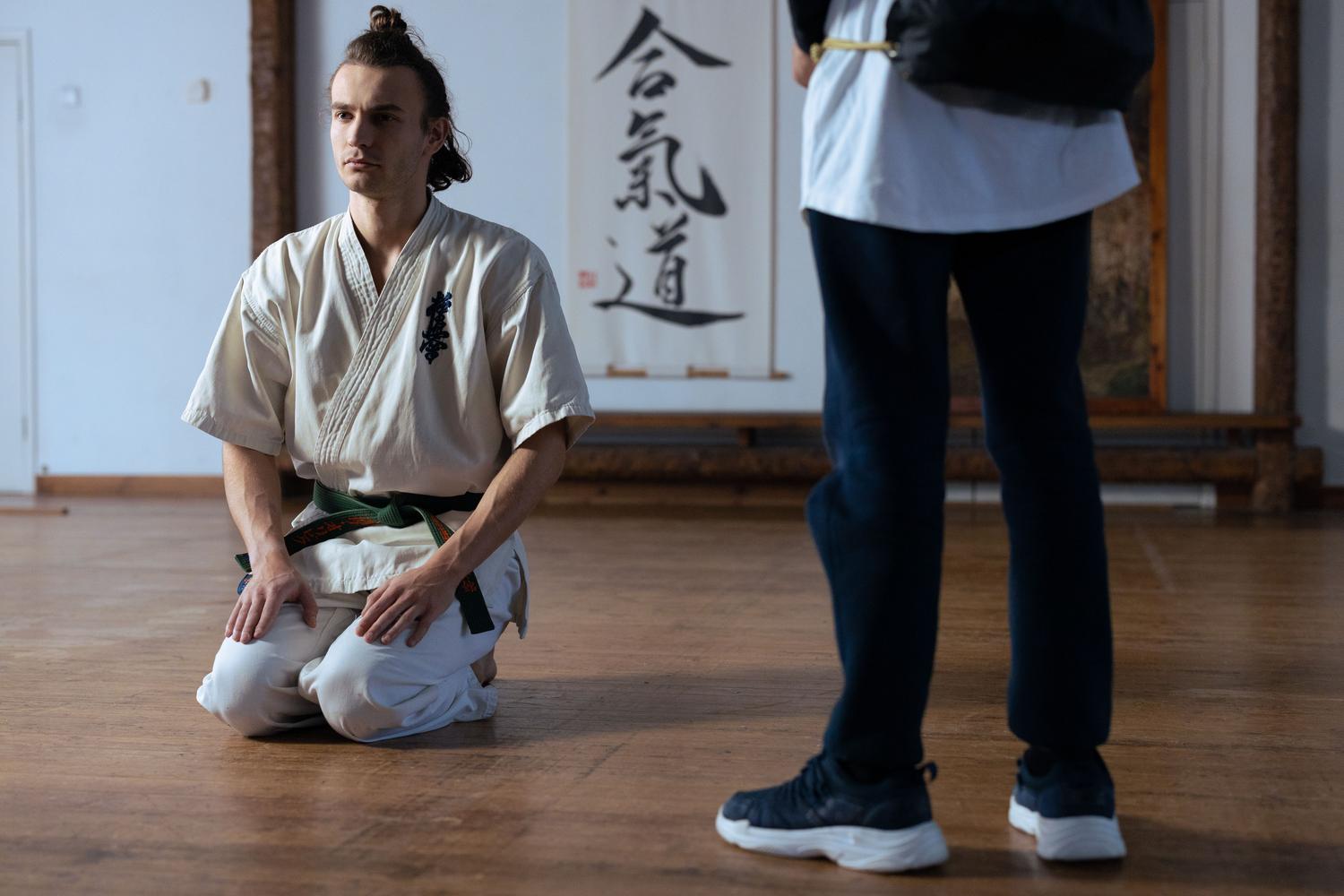 Artista marcial en entrenamiento tradicional en un dojo, concentrado y en guardia, representando la técnica y precisión del combate en Bloodless.