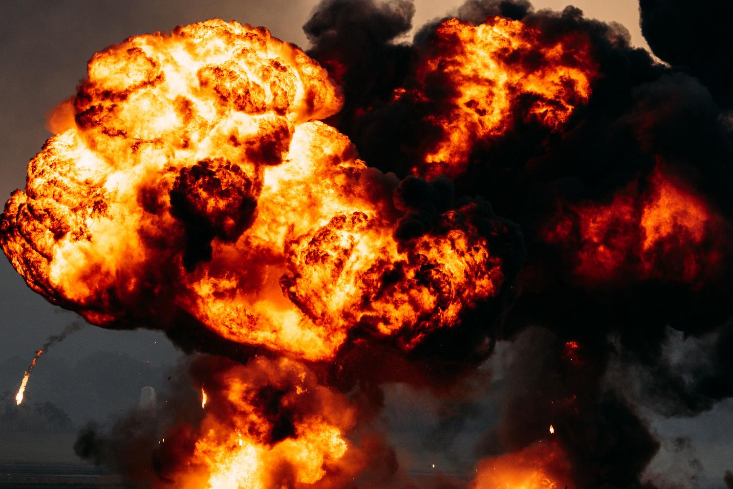 Una potente explosión de fuego y humo negro, ilustrando la mecánica de impacto explosivo de las armas Tediore.