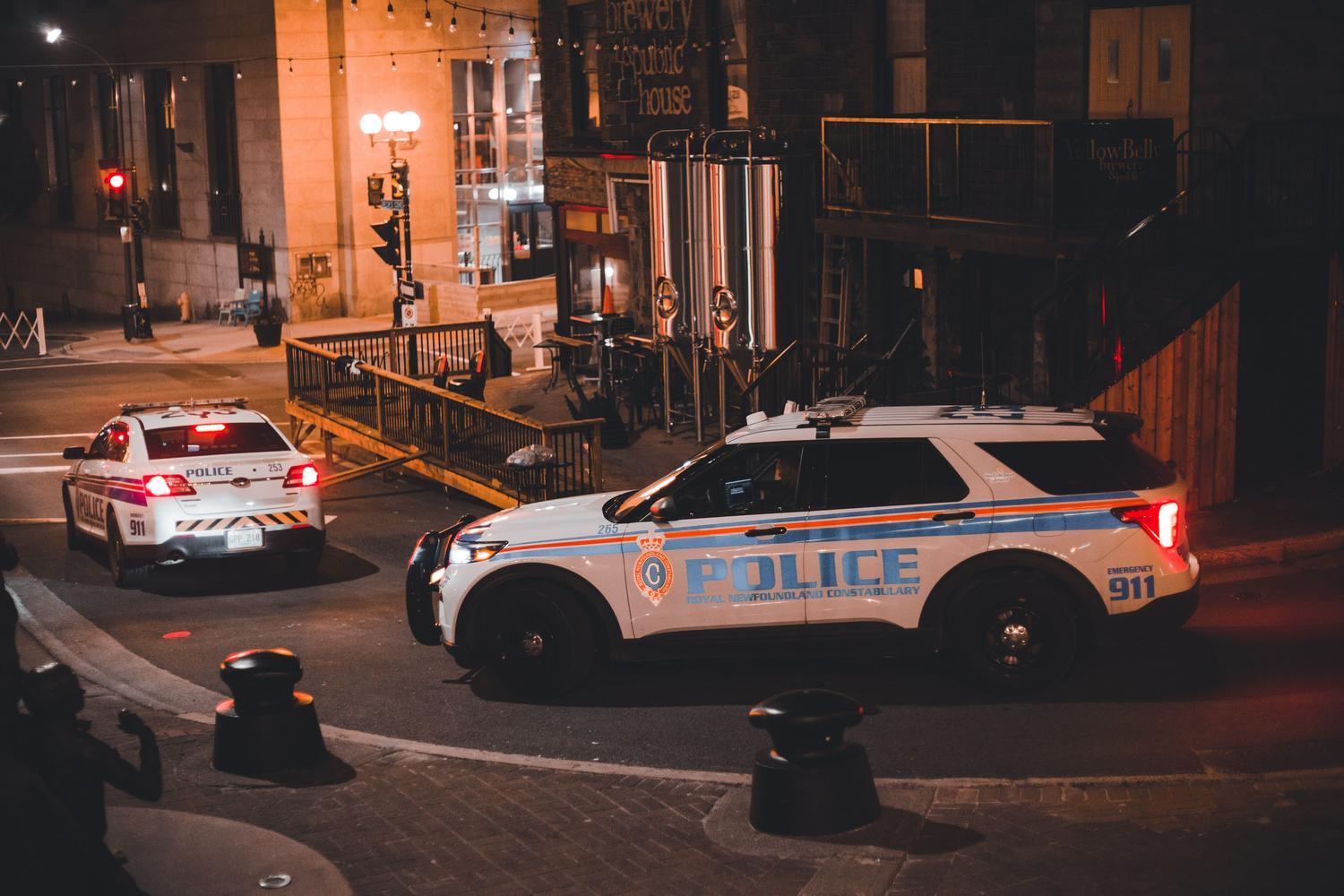 Patrullas de policía en una calle urbana durante la noche, representando los niveles de búsqueda y persecuciones.