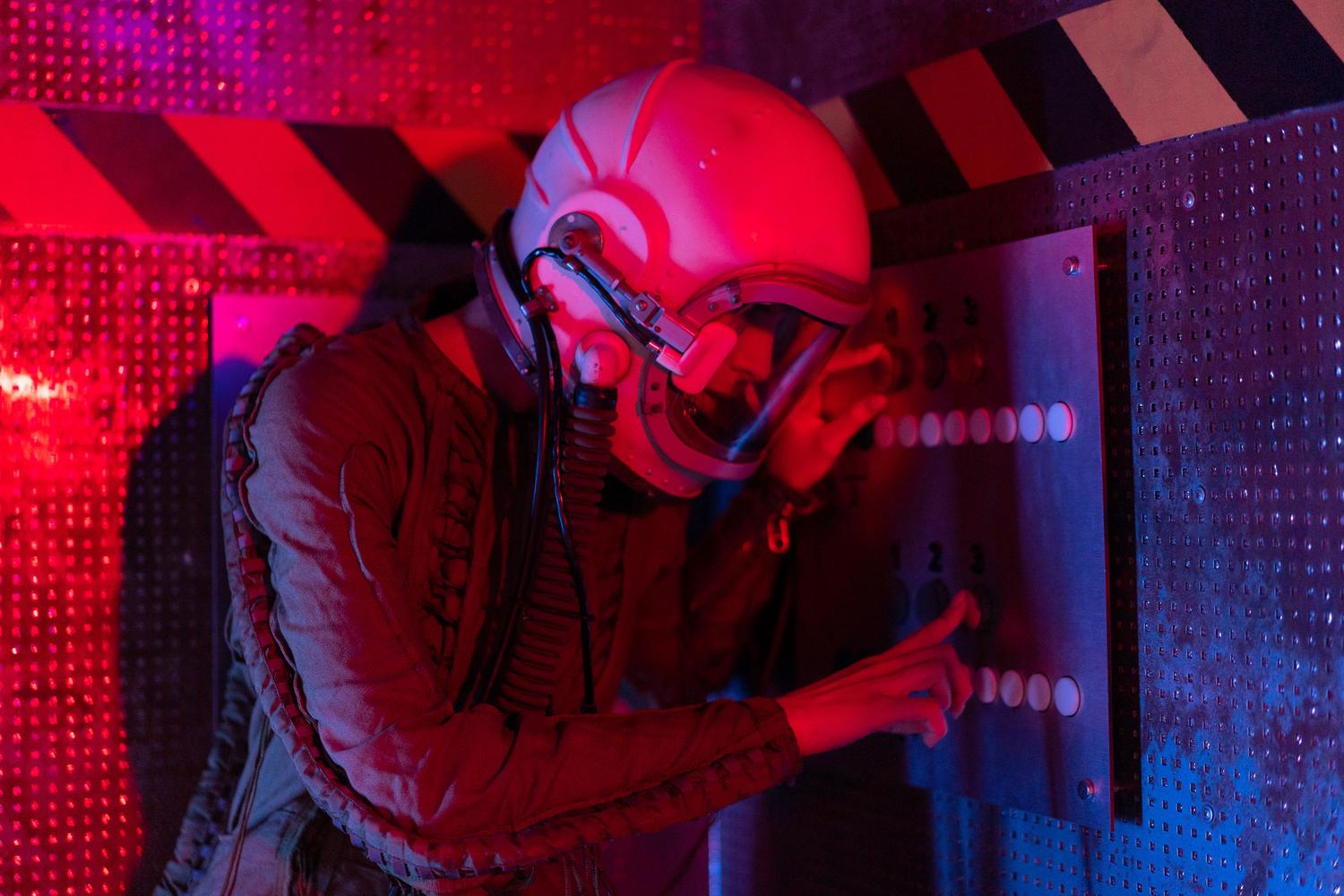 Astronauta interactuando con un panel de control en el interior de una nave futurista, ideal para ilustrar la gestión de estaciones espaciales.