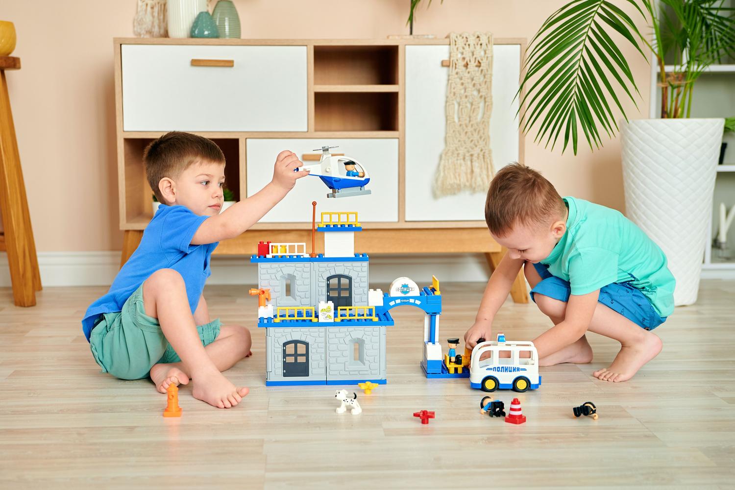 Niños jugando juntos con bloques de construcción en el suelo, destacando el enfoque familiar del simulador urbano.