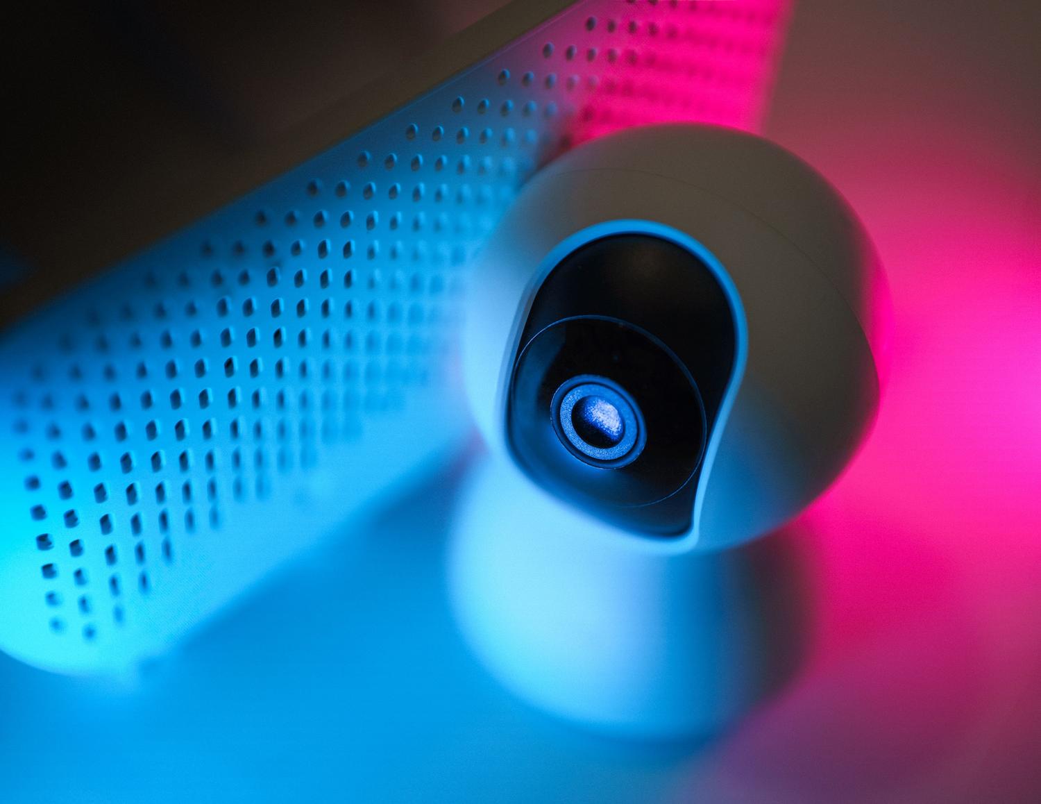 Cámara de seguridad inteligente IoT con luces de neón, representando los dispositivos del hogar que quedan blindados gracias a la VPN del router.
