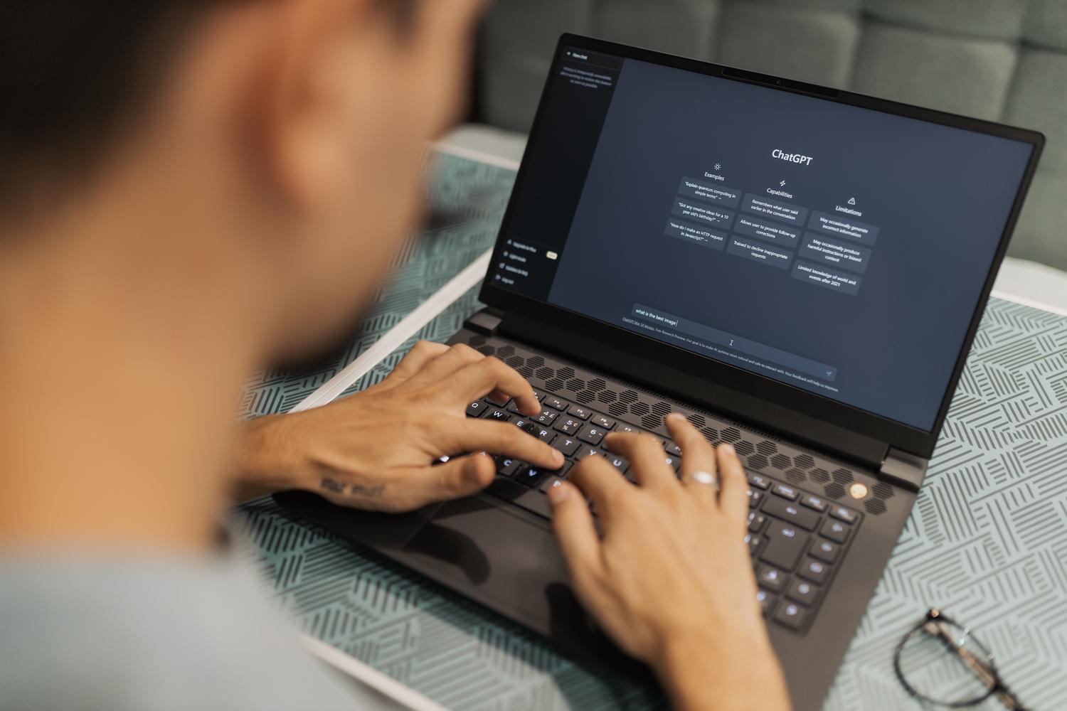 Persona utilizando un ordenador portátil con una interfaz de inteligencia artificial para mejorar la productividad.