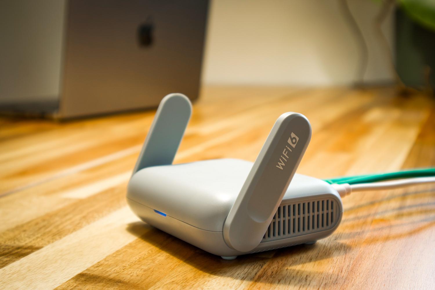 Router moderno WiFi 6 con antenas sobre un escritorio de madera, representando la configuración de red doméstica.