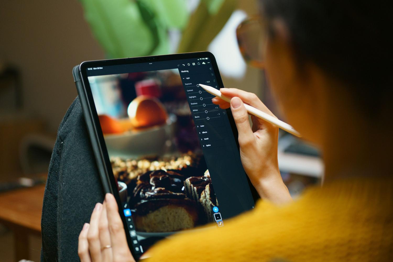 Persona utilizando una tablet y lápiz digital para editar fotografías, representando la accesibilidad de las herramientas de edición y animación por IA.