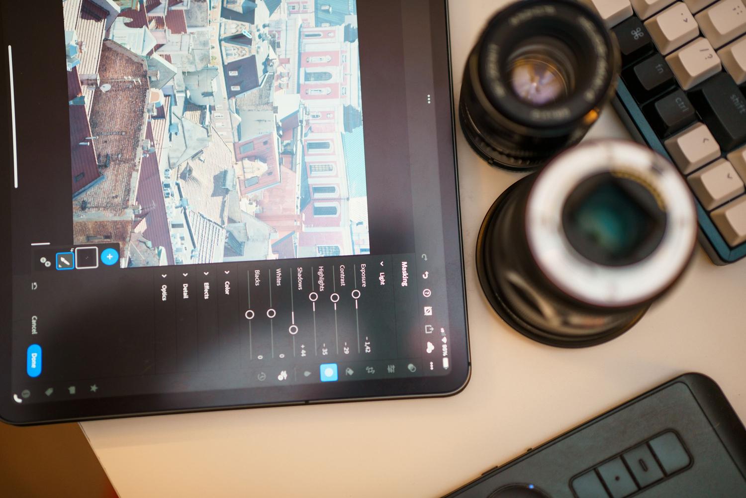 Espacio de trabajo moderno con tablet y objetivos de cámara, ilustrando el flujo de trabajo de post-producción para la creación de contenido visual.