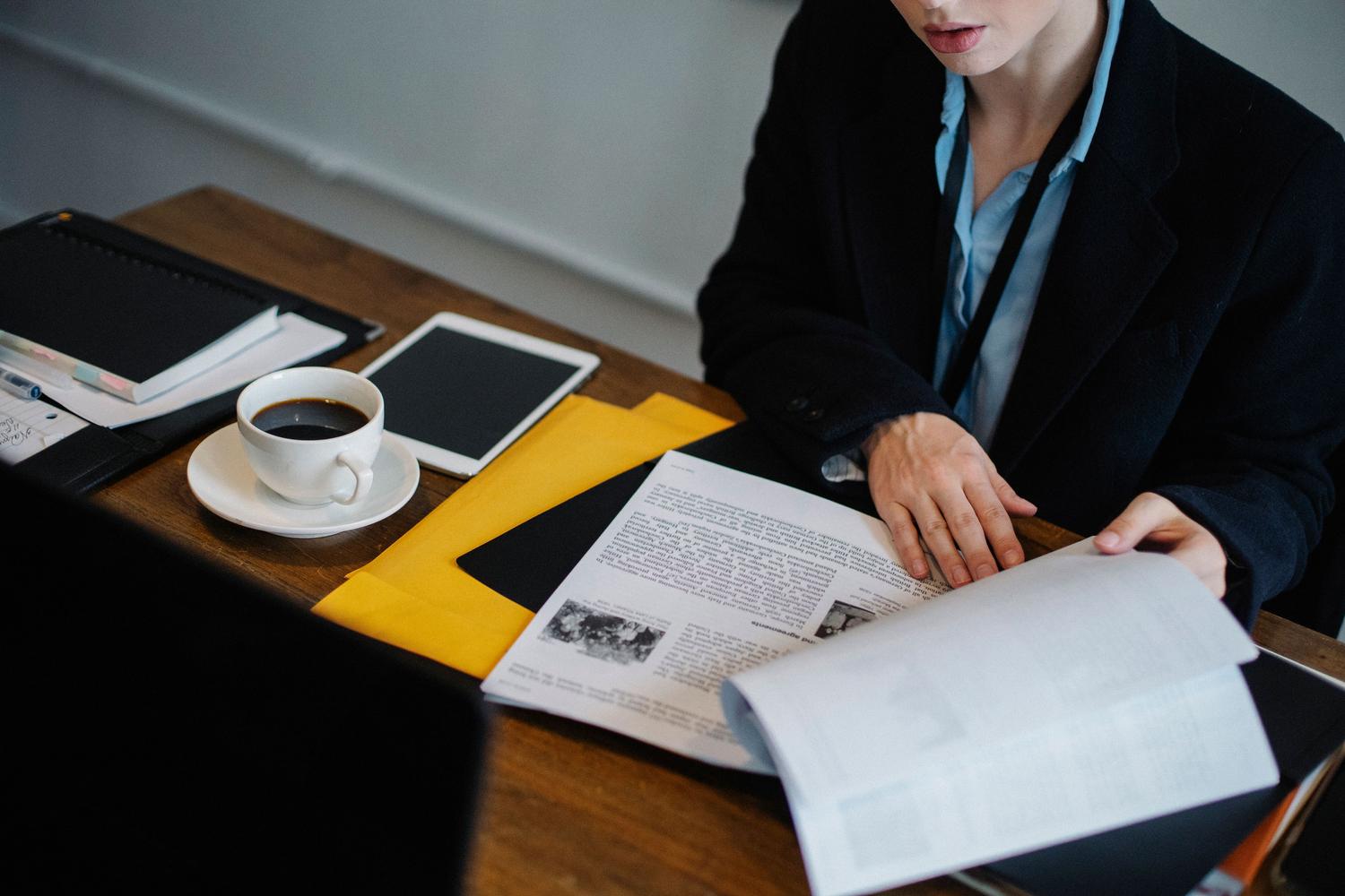Persona de negocios organizando documentos y utilizando una tablet, representando la gestión de archivos profesionales antes de subirlos a ChatGPT.