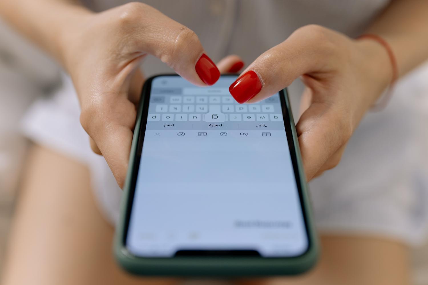 Manos escribiendo en la pantalla de un smartphone, ilustrando la gestión de aplicaciones de mensajería como WhatsApp durante el cambio de móvil.