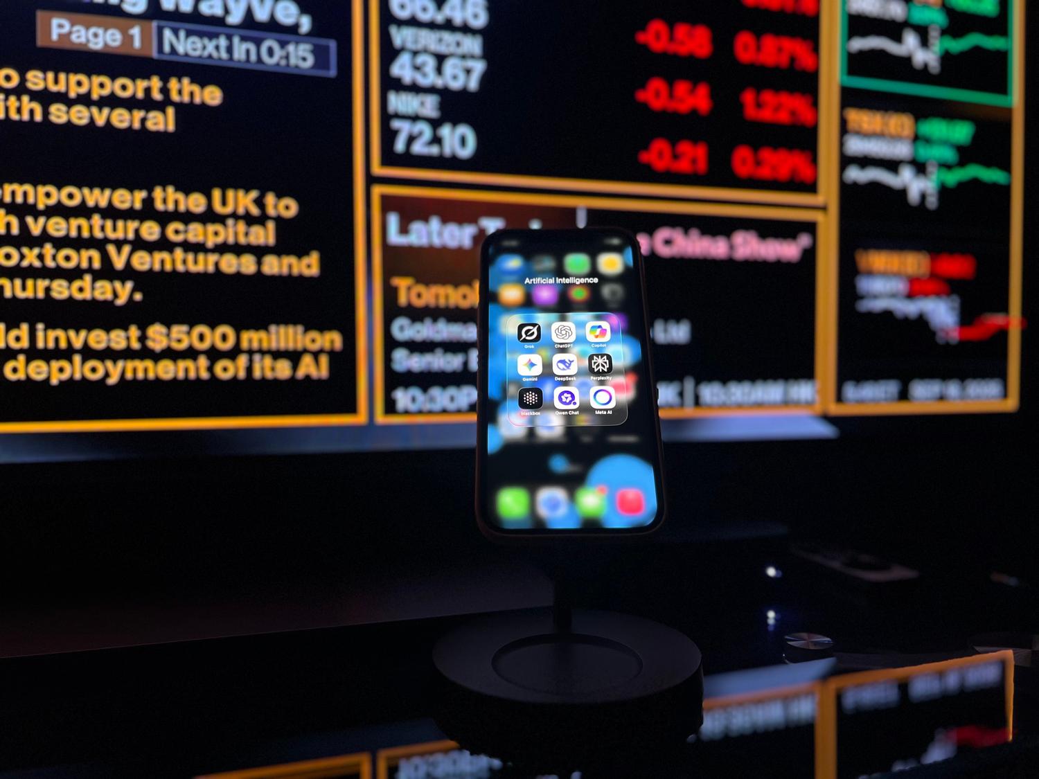 Smartphone con aplicaciones de IA frente a una pantalla de datos financieros, representando los casos de éxito de la inteligencia artificial en el sector bancario y la detección de fraudes.