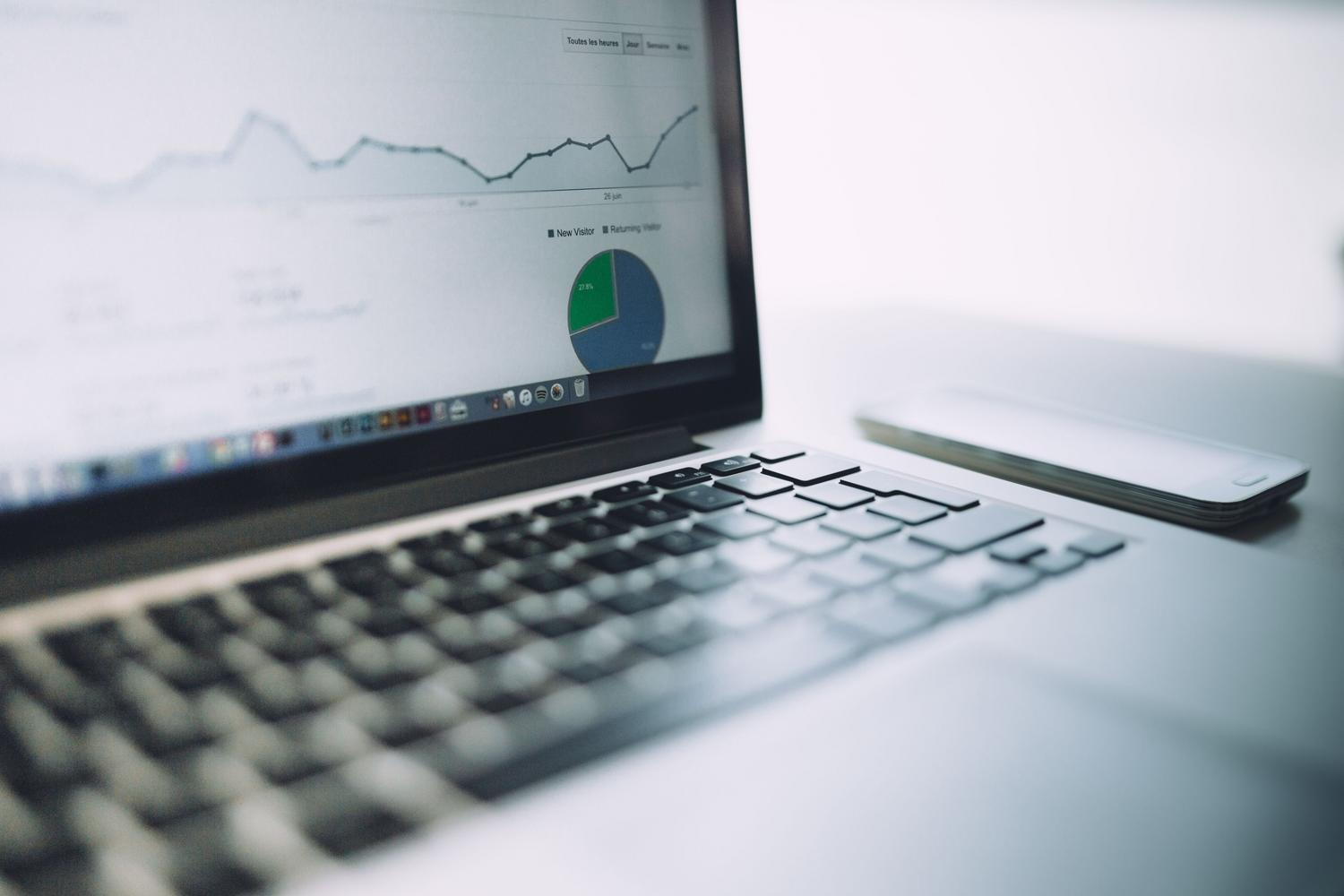 Panel de análisis de datos y gráficas en un portátil, ilustrando la optimización de campañas publicitarias y el análisis predictivo de mercados.